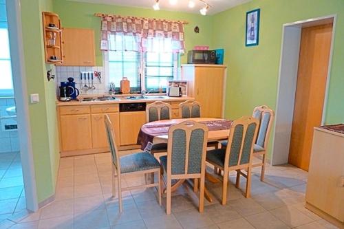 青斯特Am Deich 49的厨房以及带桌椅的用餐室。