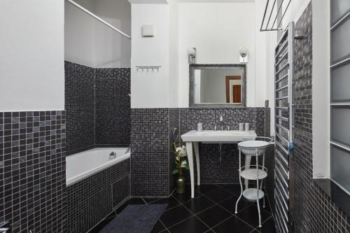 布拉格Lavish Apartment in Old Town by Prague Days的一间带水槽、浴缸和镜子的浴室