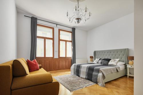 布拉格Lavish Apartment in Old Town by Prague Days的一间卧室配有一张床、一把椅子和一个吊灯。