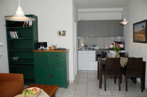 Neu KlockenhagenMaisonette-Ferienwohnung "Trakehnen"的厨房配有绿色橱柜和桌子