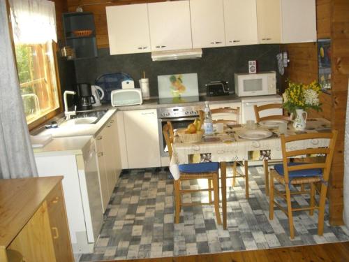 阿默灵豪森Ferienwohnung Dehnsen的厨房配有白色橱柜和桌椅