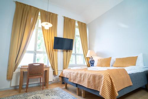 萨翁林纳Boutique Hotel Willa Aria的卧室配有一张床、一张书桌和窗户。