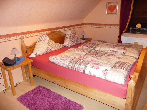 NeukirchenFerienwohnung PANTEN的一间卧室配有一张木床和紫色地毯。