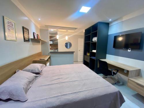 马卡帕Apartamento Studio Centro de Macapá的一间卧室配有一张大床和一张书桌