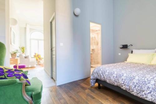第戎La Chassagne, en plein cœur de ville的一间卧室配有一张床和一把绿色椅子