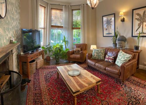 RobyLyndhurst - Victorian villa with heated pool的带沙发和咖啡桌的客厅