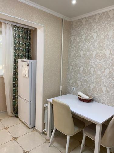 基希讷乌Apartament Chisinau str.Cuza Voda的厨房配有白色的桌子和冰箱。