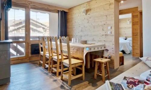 葱仁谷Apartment ski in/out Val Thorens的一间带桌椅的用餐室和一间卧室