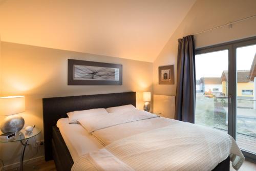 海利根港Ostsee - Appartement Nr 63 "Möwennest" im Strand Resort的一间卧室设有一张床和一个大窗户