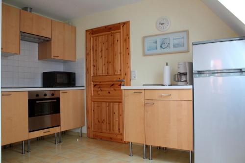 海利根港Ferienwohnung "Strand Hus 2"的厨房配有木制橱柜和冰箱。