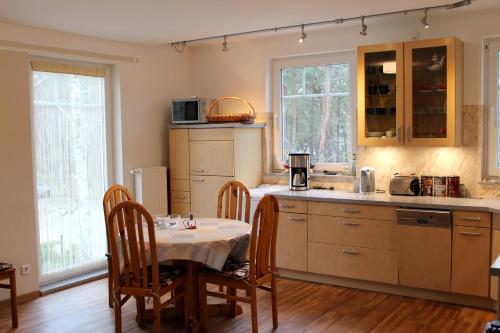 奥茨塞巴德·迪尔哈根Strandvilla Sophie App 2的厨房配有桌子和桌椅