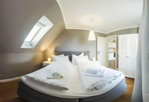 卡格斯多夫FerienDüne 4的卧室配有一张白色大床和天窗