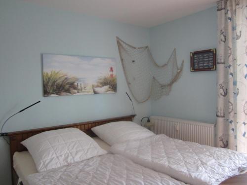 奥茨塞巴德·迪尔哈根Seepferdchen App 11的卧室配有一张床,墙上挂着一幅画