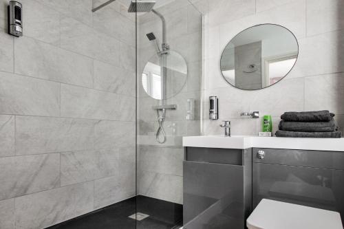 德比Emerald En-suite in Derby的带淋浴、水槽和镜子的浴室