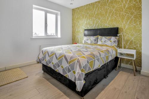 德比Emerald En-suite in Derby的一间卧室配有一张黄色和灰色的床铺
