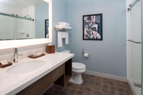 KeizerBest Western Premier Keizer Salem Hotel的一间带水槽、卫生间和镜子的浴室