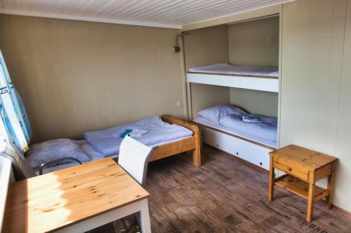 吕贝克Finnenhaus 3的小房间设有两张双层床和一张书桌