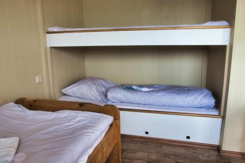 吕贝克Finnenhaus 3的小房间设有两张双层床,配有背风性关节炎性关节炎性关节炎