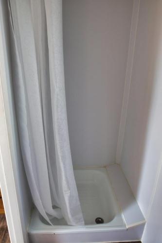 吕贝克Finnenhaus 3的淋浴旁配有白色淋浴帘的淋浴