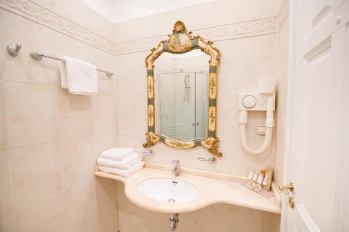 帕特雷Palaiologos Luxury City Hotel的一间带水槽和镜子的浴室