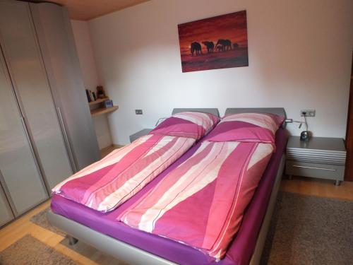 弗里茨拉尔Ferienwohnung Iris的卧室内的一张床位,配有粉色和白色的毯子