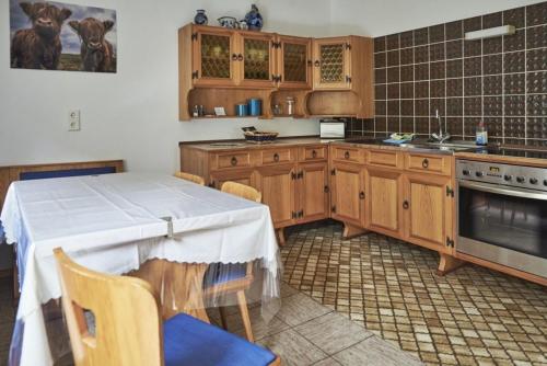 巴特贝勒堡Fewo Bubenberg的厨房配有木制橱柜和桌椅