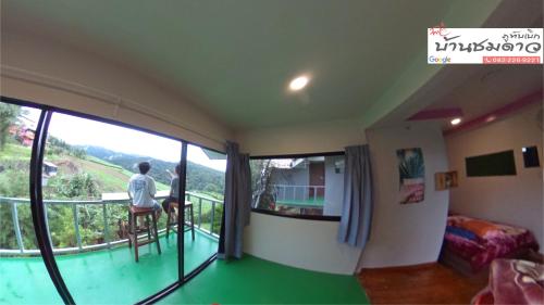 碧差汶Baan Chomdao Phu Thap Buek的两人坐在带阳台的房间