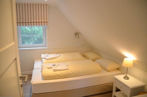 威克奥夫弗尔Am Maisfeld Ferienhaus的一间卧室配有一张带黄色床单的床和一扇窗户。
