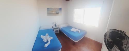弗龙特拉Puestita de Sol的客房设有蓝色的床和窗户。