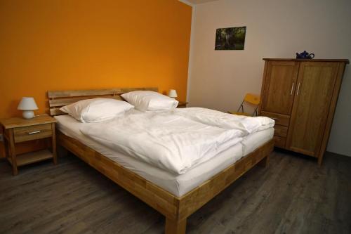 马尔洛Ferienhaus am Vogelpark - Trebelhaus Gesine的一间卧室配有带白色床单和枕头的床。