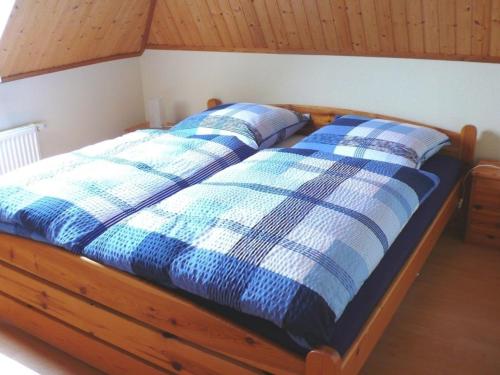 奥斯特巴德里克Ferienwohnung "Uferschwalbe"的一张带两个蓝色和白色枕头的床