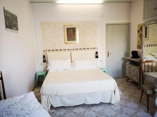 博尔塞纳B&B L ORTENSIA的卧室配有白色大床和梳妆台