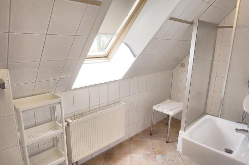 青斯特An der Galerie, A 11的浴室设有窗户、水槽和浴缸。