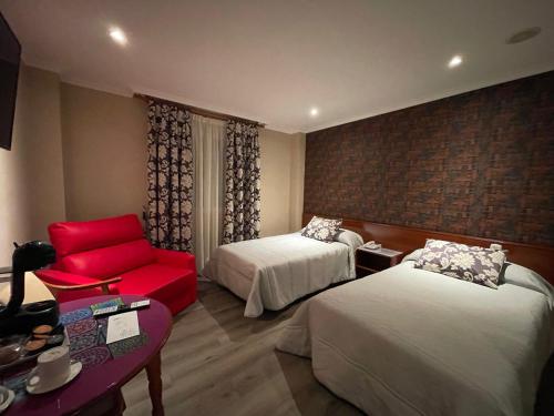 VillamarcielLa Siesta的酒店客房,设有两张床和一张红色椅子