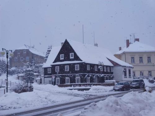 克拉斯纳利帕Cafe Nostalgie dvoulůžkový romantický pokoj的雪覆盖的城市里一个大房子