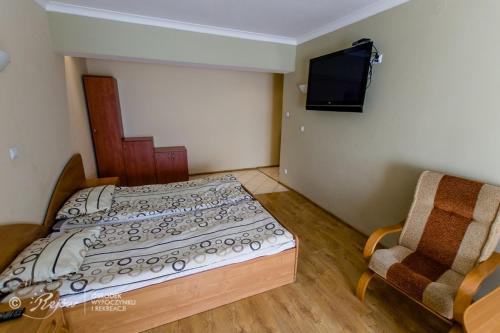 斯卡日斯科-卡缅纳OWiR Rejów的一间小卧室,配有一张床和一把椅子