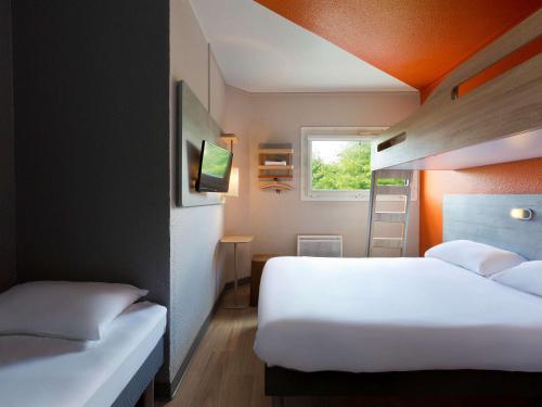 勒芒ibis budget Le Mans Universite的酒店客房设有两张床和窗户。