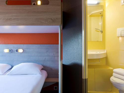 勒芒ibis budget Le Mans Universite的一间卧室配有一张床,浴室设有卫生间