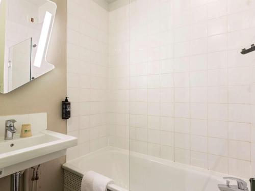 布尔昆Ibis Budget Bourgoin Jallieu Centre的白色的浴室设有浴缸和水槽。