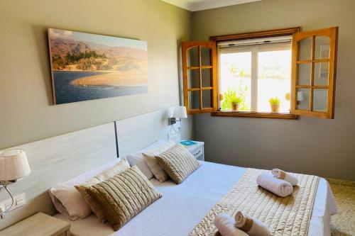 萨洛夫雷2 Apartments with private pool at Villa Diaz Aleman的卧室配有带枕头的床铺和窗户。