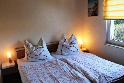 赫亨基尔兴Blaues Haus mit Meerblick的一间卧室配有带白色床单和枕头的床。