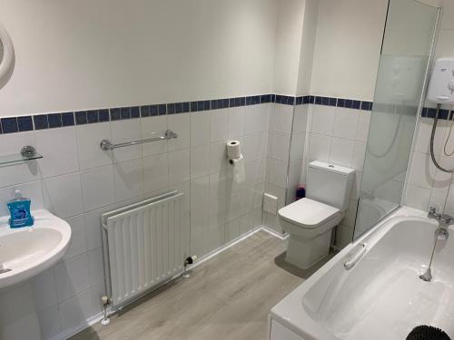 格拉斯哥Flat Two, 212 Eaglesham Road, East Kilbride, Glasgow的带浴缸、卫生间和盥洗盆的浴室
