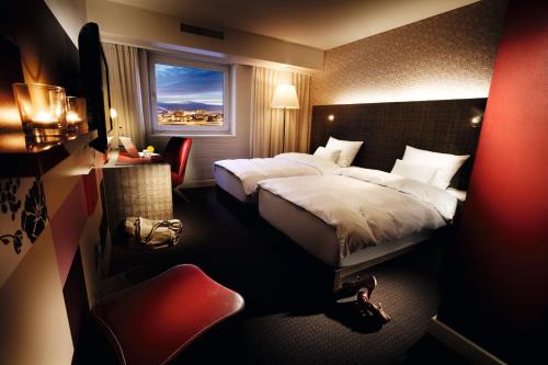 威斯巴登pentahotel Wiesbaden的酒店客房设有床和窗户。
