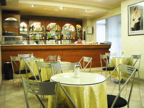 巴迪亚尔皮诺阿雷佐波斯塔旅馆的一间带桌椅的餐厅和酒吧
