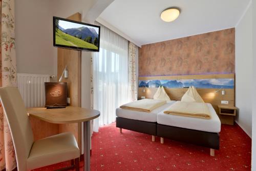 韦斯滕多夫阿畔豪夫酒店的酒店客房配有一张床、一张书桌和一台电视。