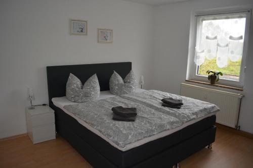 NeukieritzschFerienwohnung am Hainer See的一间卧室配有一张带两个黑色枕头的床