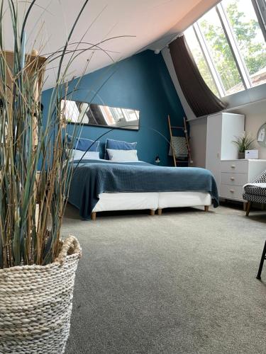 布鲁日阁楼宾馆的一间卧室设有一张床和蓝色的墙壁
