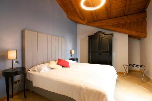 MiazzinaHotel Milano & Apartments的卧室配有带红色枕头的大型白色床