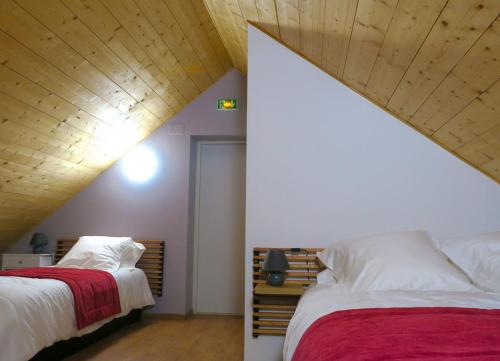 ArlosL'Ôberge的一间卧室设有两张床和木制天花板