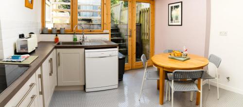 马汉莱斯Bwthyn Gweilch的厨房配有木桌和小桌子及椅子